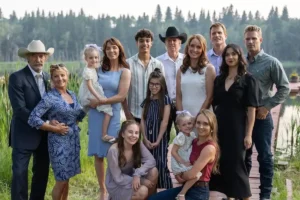 Cast of Heartland Season 18 standing together near a lake with title text overlay reading ‘Heartland: Season 18 – Still Riding Strong