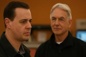 McGee looks intensely focused as Gibbs stands behind him in soft focus, symbolizing the emotional return of Gibbs in NCIS Season 22, Episode 19.